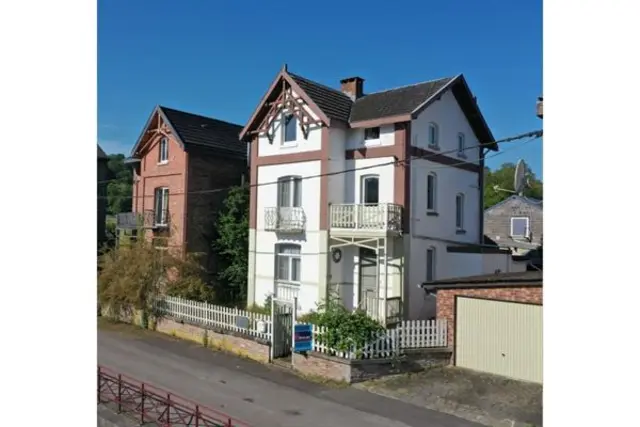 Karakteristiek woonhuis met garage en tuin.