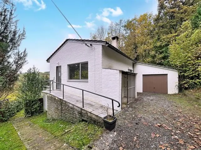 Beknopte bungalow met garage en tuin aan rustige landweg.